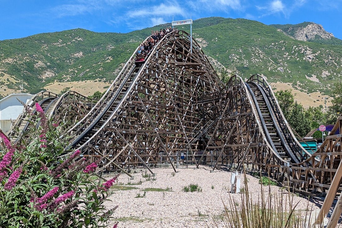 A wooden roller coaster with a tall first hill followed by smaller hills