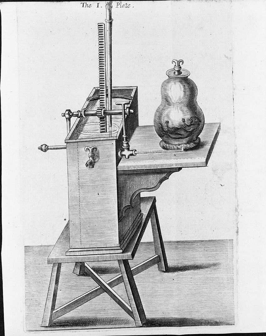 Engraving of an air pump: a tall box with a rack and handle on a wooden stand, joined by a pipe to a glass vessel with a small animal inside