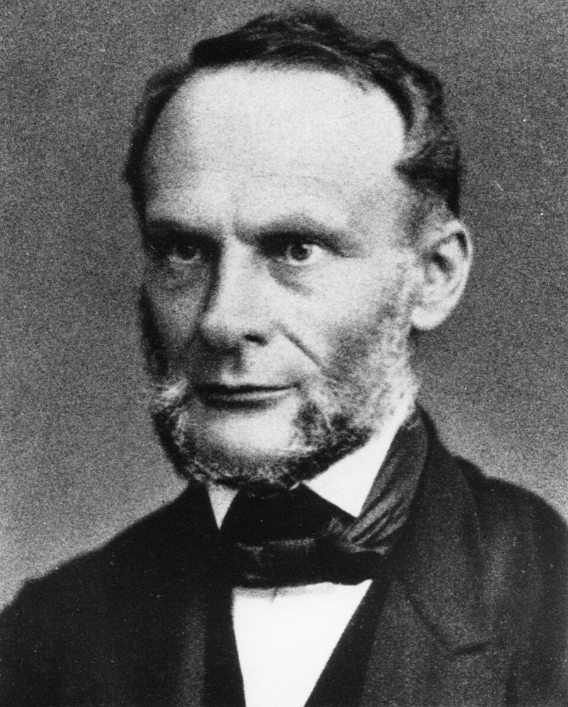 Photographic portrait of Rudolf Clausius, an older man with white hair and a white beard, in a dark coat